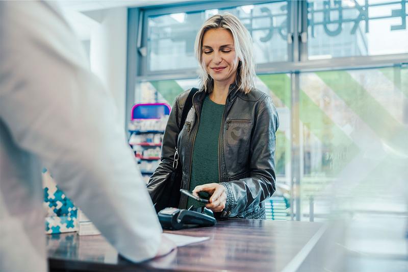 women tapping phone on in a shop